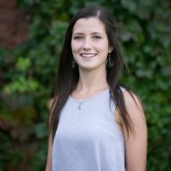 Portrait of Jessica Archibald: Woman with long brown hair posing in baby blue blouse